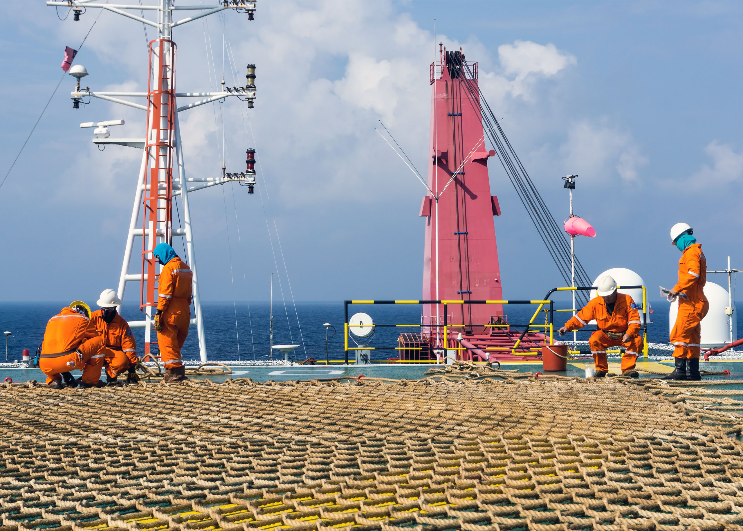 Visual research depicting oil rig employees working with a cargo net.